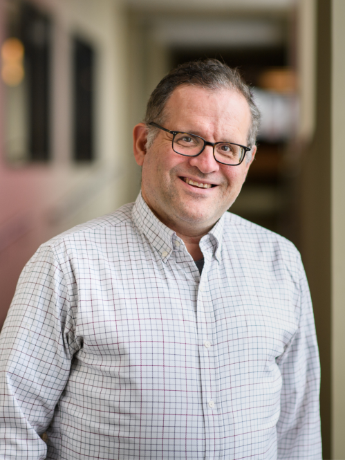 a man with glasses smiling