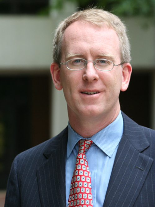 a man with glasses smiling