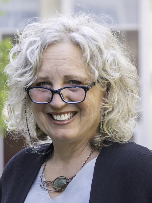 a woman with glasses smiling