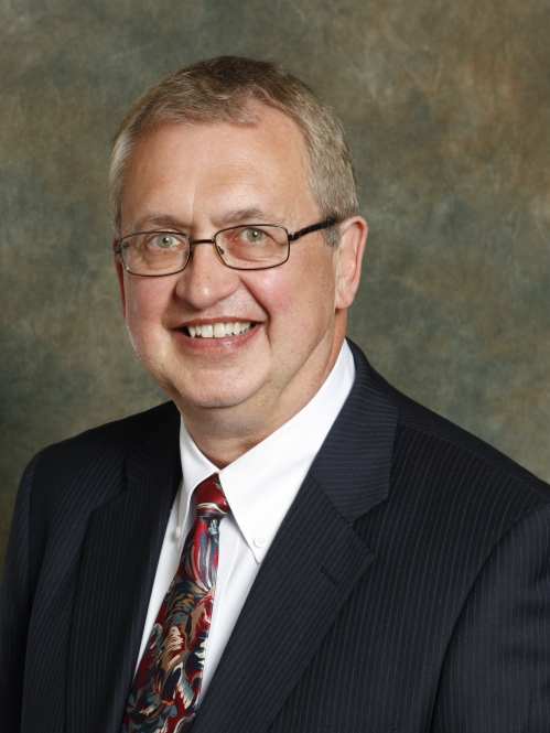 a man with glasses smiling