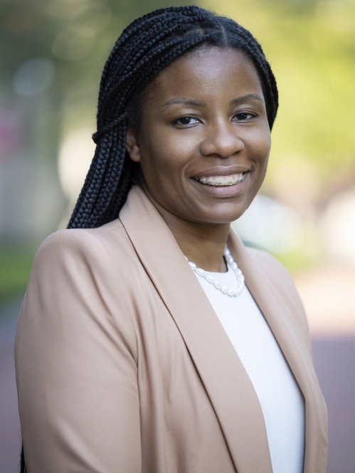 woman in brown blazer smiling
