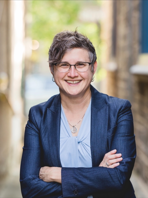 a woman with glasses smiling