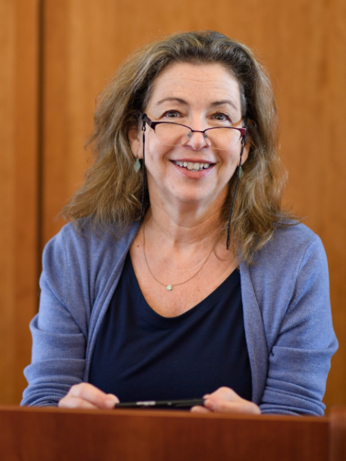 a woman with glasses smiling