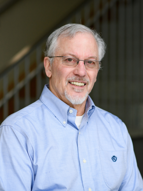 a man with a beard and glasses smiling