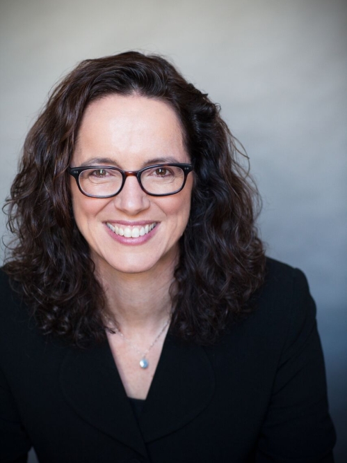 a woman with glasses smiling