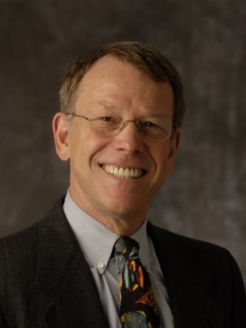 a man with glasses smiling