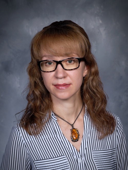 a woman with glasses smiling