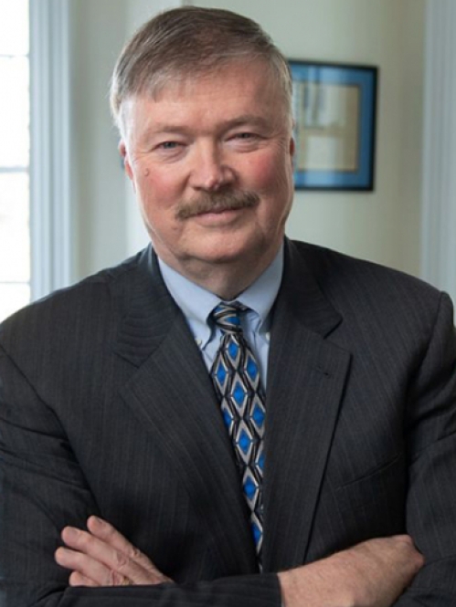 man in suit with folded arms smiling