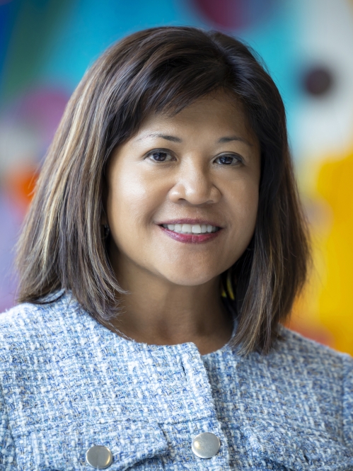 woman smiling in front of blurred art mural
