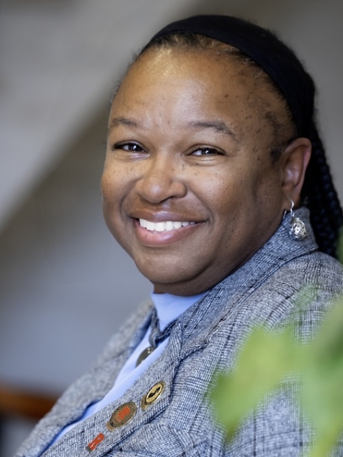 woman smiling with head turned near green plant