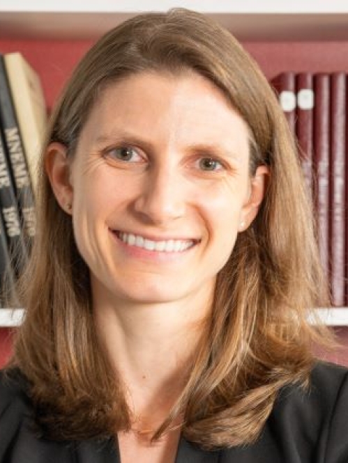 woman smiling in front of bookcase