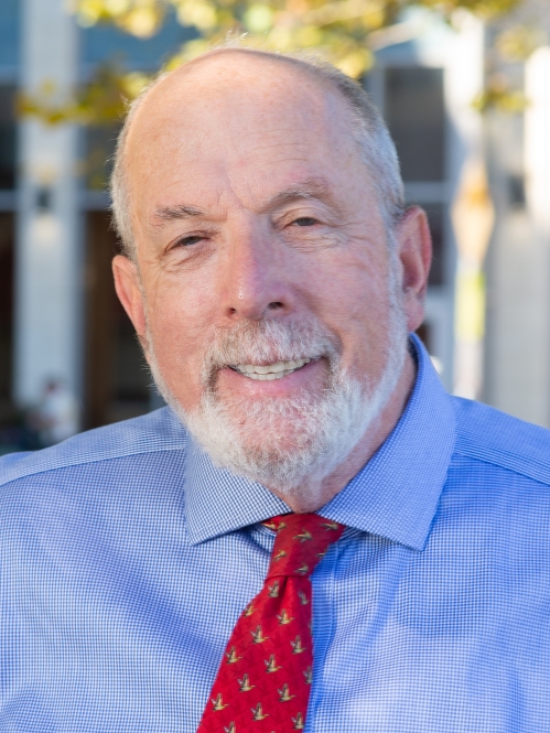 Man smiling wearing blue button down shirt and red tie