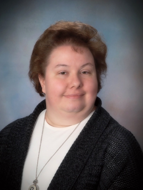Woman grinning wearing white shirt and black sweater 