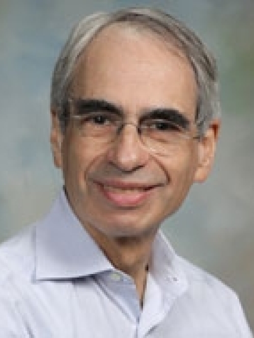 Man smiling with glasses wearing a blue button down shirt