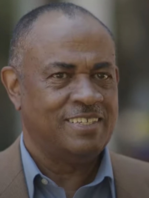 man in brown jacket smiling