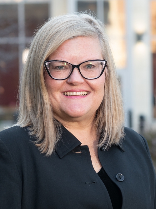 Woman smiling with glasses wearing a black shirt