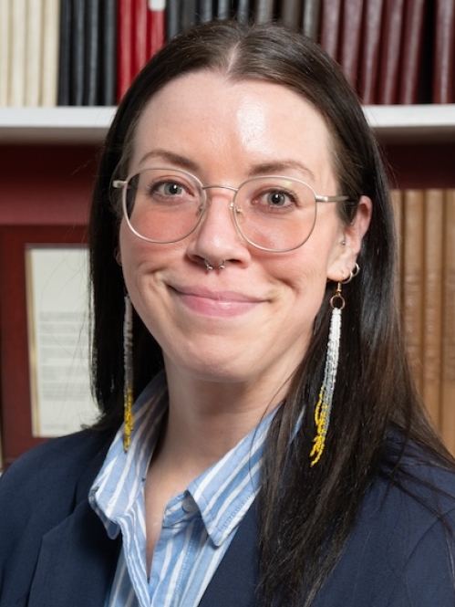 Woman grinning in front of bookcase