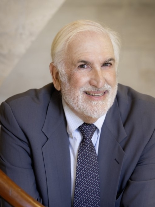 man in blue suit smiling on staircase