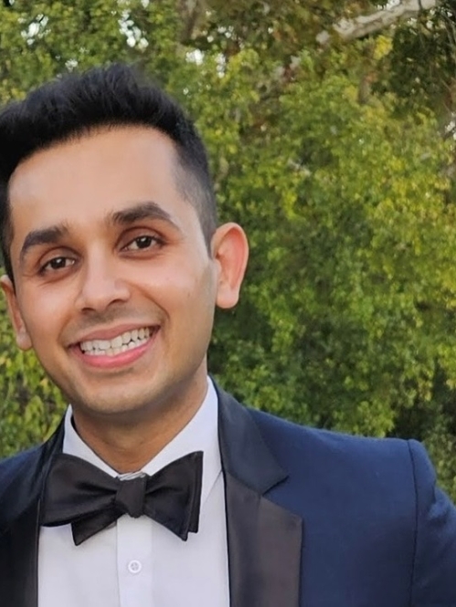 man in blue tux and bowtie smiling