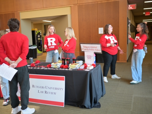 women in red R Law tops talking to each other