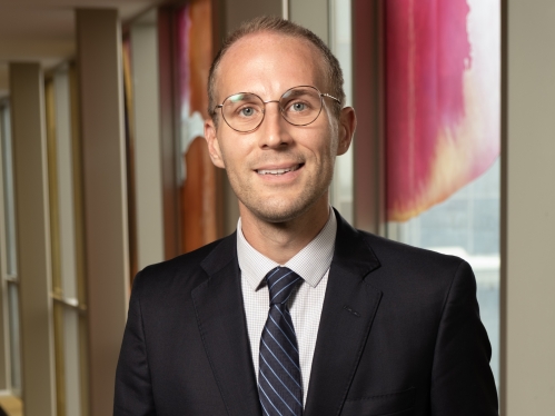 a man with glasses smiling