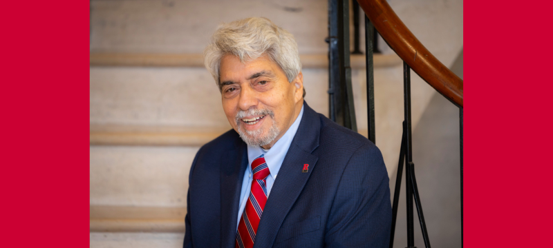 man smiling in blue business suit sitting on stairs indoors 