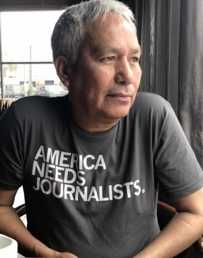 Photograph of a man with white hair in a t-shirt