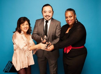 a group of people holding an award and posing for a photograph