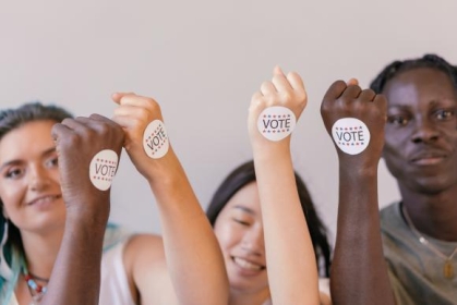 group of people raising their hands with a "vote symbol"