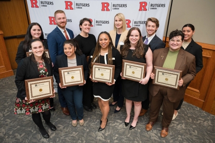 group of men and women smiling and holding plaques