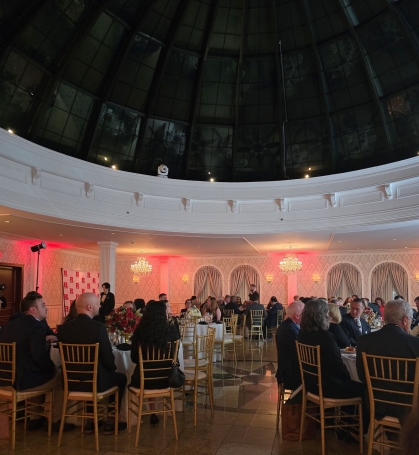 group of people seated at round tables in catering hall