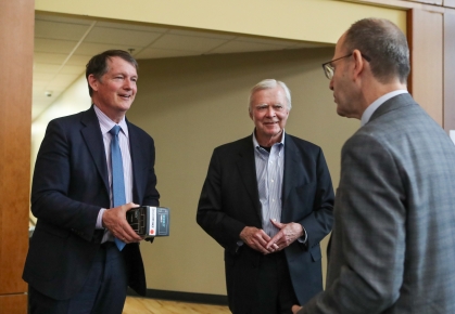 three men in suits standing and talking to each other