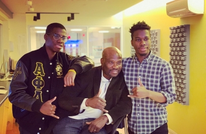 one man seated flanked by his two sons standing