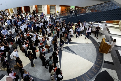 woman speaking at podium to large crowd