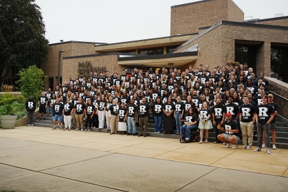 large group on steps wearing black and white tshirts
