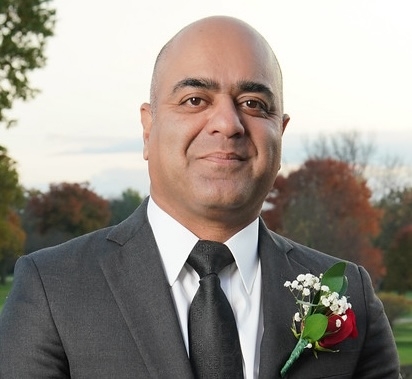 man in suit smiling with rose on lapel