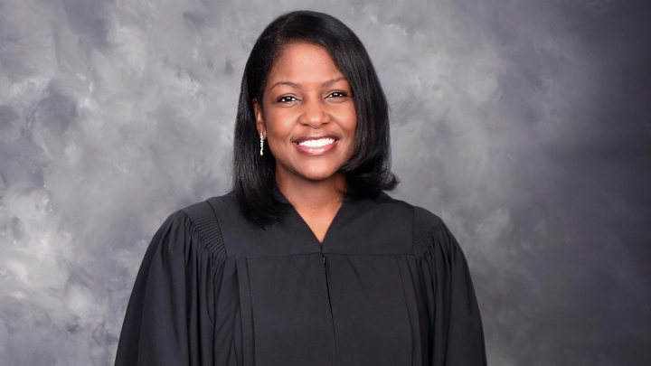 woman in black judge's robe smiling