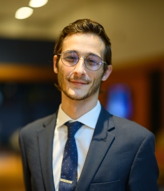man in suit and glasses smiling