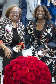 Two women sitting, smiling, and posing for the camera