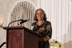 woman speaking behind a podium