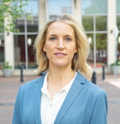 woman in blue blazer standing outside