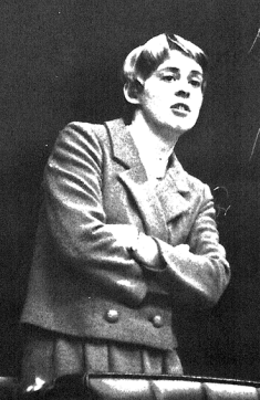 black and white photo of woman standing with folded arms