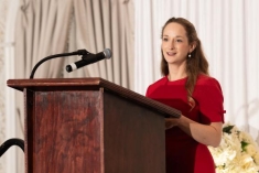 woman speaking behind a podium