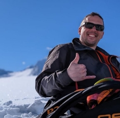 man sitting in snow posing for a photograph