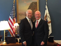 photograph of two men in suits posing next to each other