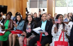 group of people sitting and holding American flags