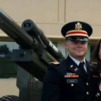 Man in military uniform near canon