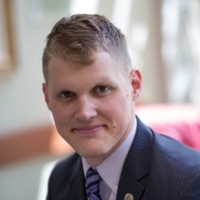 man in blue suit grinning