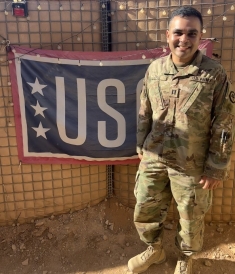 Man in military uniform in front of USO sign