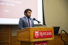 Man in a suit speaking behind a podium